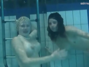 Two naked young chicks swim in the pool